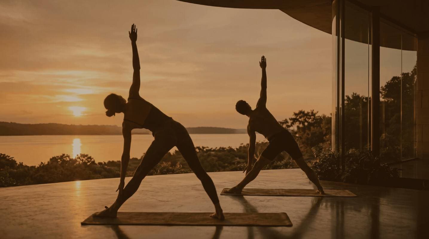 Prática de wellness com vista para a lagoa ao pôr do sol